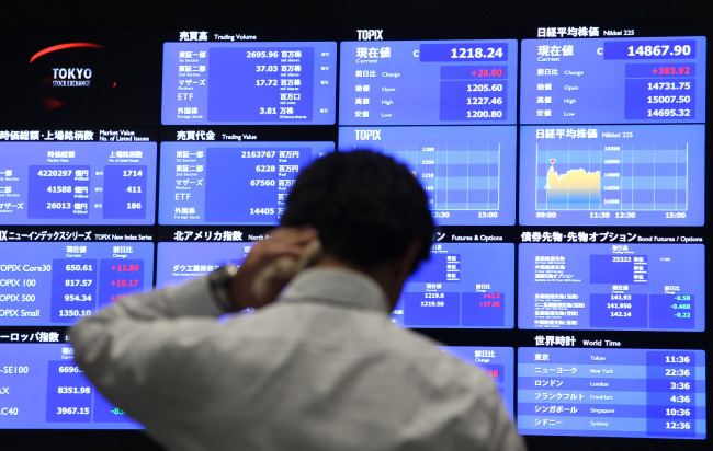 A visitor looks at an electronic stock board at the Tokyo Stock Exchange in Tokyo on Friday. (Bloomberg)