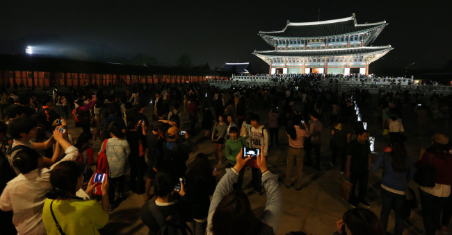 A large crowd gathers inside Gyeongbokgung Palace in downtown Seoul on Wednesday night, the first night this year for the palace to be open for public viewing. (Yonhap News)