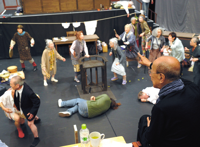 Theater director Yukio Ninagawa (right) watches the stage rehearsal of “Karasu yo, Oretachi wa Tama o Komeru (Crows, We Will Load Bullets)” at the Saitama Arts Theater in Saitama, a northern suburb of Tokyo, on April 27. (AFP-Yonhap News)