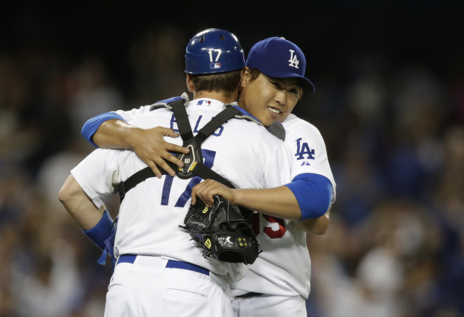 Los Angeles Dodgers starting pitcher Ryu Hyun-jin (right) hugs catcher A.J. Ellis after throwing a complete game against the Los Angeles Angels on Tuesday. (AP-Yonhap News)