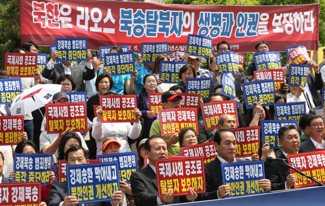 Activists protest Laos’ repatriation of nine North Korean defectors at a rally organized by the Korea Freedom Federation in Seoul on Tuesday. (Yonhap News)