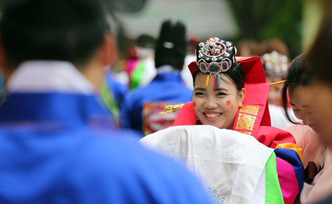 A bride goes through a group Korean traditional wedding ceremony at Seocho Culture and Arts Park in southern Seoul on May 22. The event was held for migrant spouses who did not have a wedding ceremony. (Yonhap News)