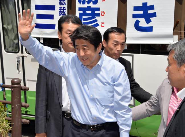 Japanese Prime Minister Shinzo Abe waves to his supporters after delivering a speech for the Tokyo Metropolitan Assembly election in Tokyo on Sunday. (AFP-Yonhap News)