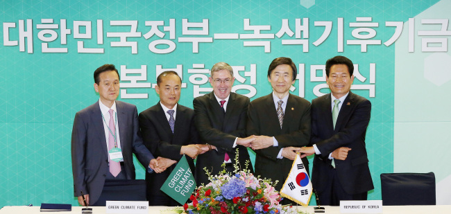 Foreign Minister Yun Byung-se (second from right), and Green Climate Fund co-chairman Ewen McDonald (center), Incheon Mayor Song Young-gil (right) and other officials pose after signing an agreement to establish the U.N. agency’s headquarters in the city’s business district of Songdo. (Yonhap News)