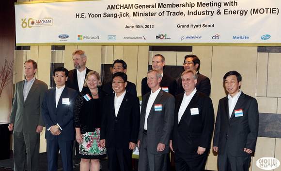 Industry Minister Yoon Sang-jick (fourth from left, front row) and AMCHAM Korea chairman Pat Gaines (fifth from left, front row) pose with chamber members during a meeting on foreign investment in Seoul on Monday. (Courtesy Ilyo Sisa)