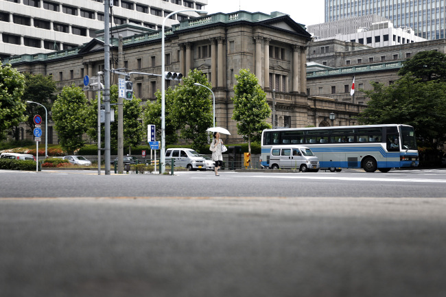 A pedestrian crosses the road in front of the Bank of Japan headquarters in Tokyo. (Bloomberg)