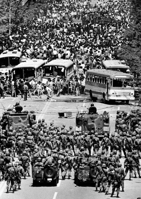 Pro-democracy protesters confront armed troops on the main street of Gwangju in May 1980. A new history textbook authored by conservative scholars is criticized by progressive groups for misrepresenting the Gwangju Democratic Movement. (May 18 Memorial Foundation)