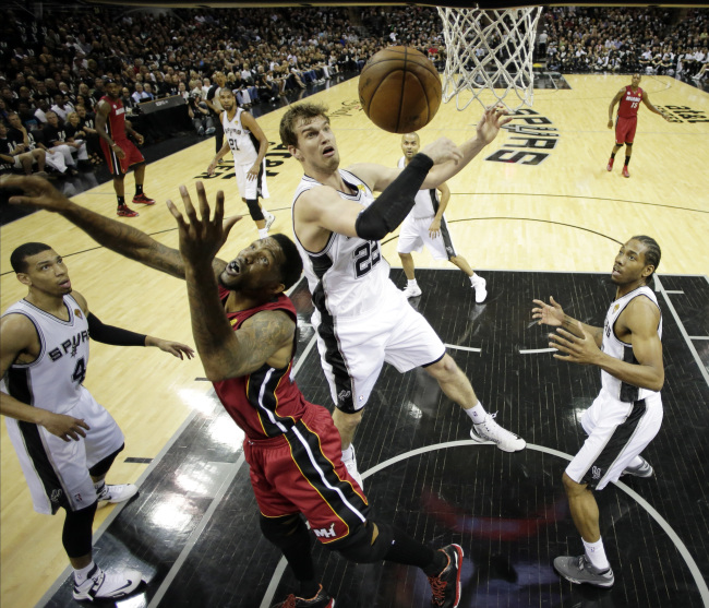 San Antonio Spurs` Tiago Splitter (22), of Brazil, and Miami Heat`s Udonis Haslem battle for a rebound during the first half at Game 3 of the NBA Finals basketball series, Tuesday