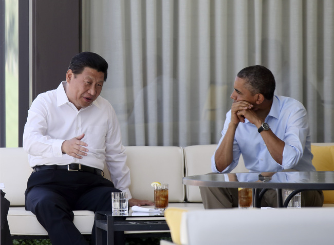 Chinese President Xi Jinping and U.S. President Barack Obama talk on a bench before heading into their second meeting, at the Annenberg Retreat, California, Saturday. (Xinhua-Yonhap News)