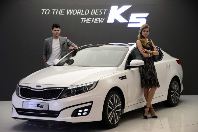 Models pose with Kia Motors’ mid-sized sedan “The New K5” at a launch event in Seoul on Thursday. (Park Hae-mook/The Korea Herald)