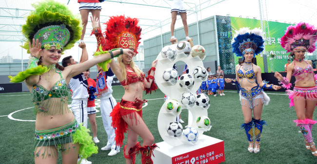 Samba dancers on Thursday pose to mark the opening of a futsal court in Yongsan I’PARK mall in Seoul and wish for South Korean football squad’s advance to and good performance at the 2014 World Cup in Brazil. (Kim Myung-sub/The Korea Herald)