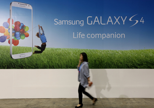 A woman walks past an advertisement for the Samsung Electronics Co. Galaxy S4 smartphone. (Bloomberg)