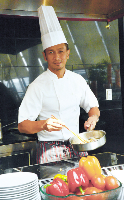 Filipino chef Sau Del Rosario cooks during his visit to promote Philippine cuisine at the Millennium Seoul Hilton on June 5. (Chung Hee-cho/The Korea Herald)