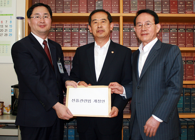 Saenuri Party lawmaker Ahn Hyo-dae (center) and Sunfull founder Min Byoung-chul (right) pose with Lee Jung-eun, an official of the National Assembly Secretariat, as they submit “Sunfull” bills against malicious online comments to the secretariat on Thursday. (Yonhap News)