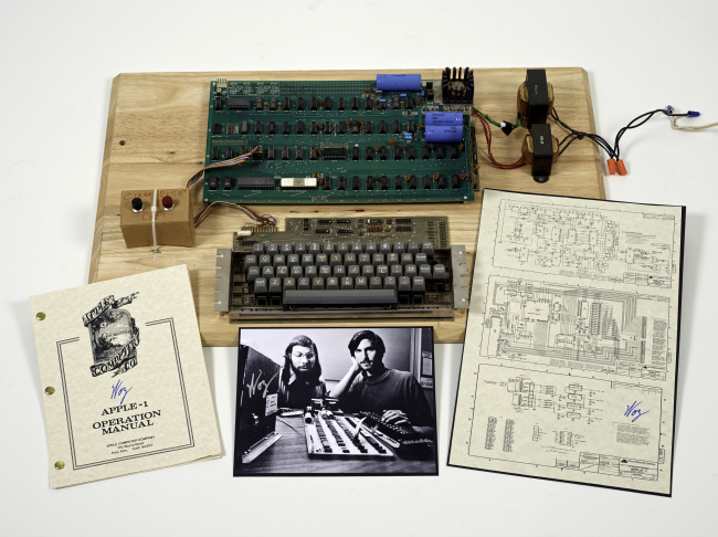 An “Apple 1” prototype computer, built in 1976, accompanied by an operation manual and schematic as well as a photo of its inventors, Steve Wozniak (left) and Steve Jobs. (AP-Yonhap News)