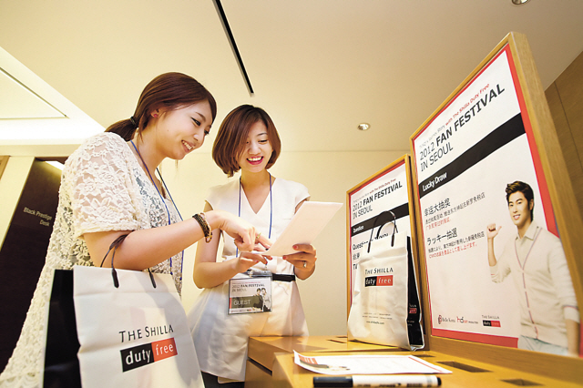 Customers at Shilla Duty Free Shop sign up for a fan meeting with TVXQ