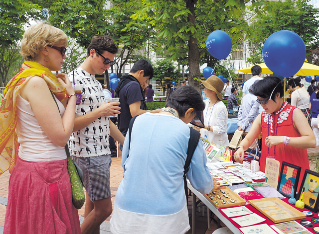 Foreign visitors browse items at Sejong Art Market SoSo in the back garden of Sejong Center for the Performing Arts in central Seoul. (Sejong Center for the Performing Arts)