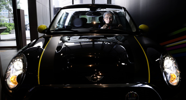 BMW Korea CEO Kim Hyo-joon poses in a Mini car on Thursday at the company’s headquarters in Seoul. (Park Hae-mook/The Korea Herald)