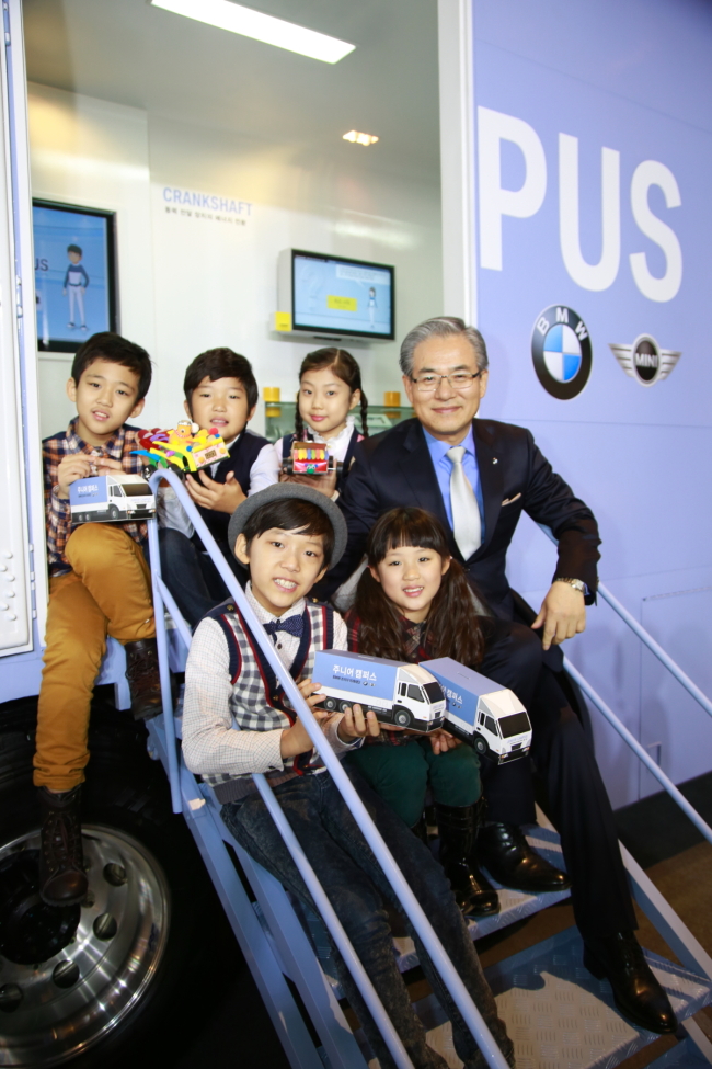 BMW Korea CEO Kim Hyo-joon poses with children participating in the junior campus program that travels across Korea to offer basic science education. (BMW Korea)