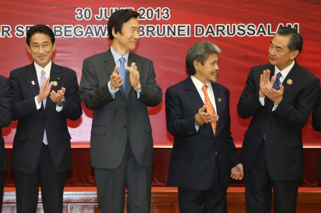 South Korean Foreign Minister Yun Byung-se (second from left) claps while attending a ceremony of the ASEAN Plus Three Foreign Minister Meeting at the ASEAN Regional Forum in Bandar Seri Begawan, Brunei Darussalam, Sunday. On the left is Japanese Foreign Minister Fumio Kishida and on the far right is Chinese Foreign Minister Wang Yi. (Yonhap News)