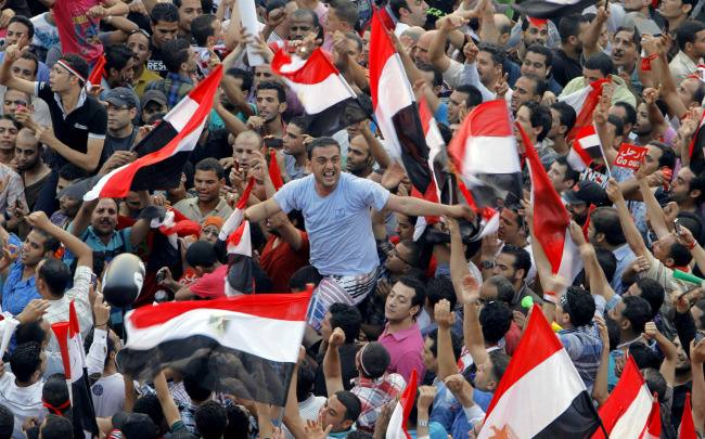 Opponents of Egypt's Islamist President Mohammed Morsi shout slogans and wave a national flags in Tahrir Square in Cairo, Egypt, Wednesday. (AFP)