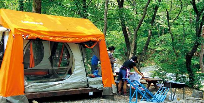 Campers prepare for lunch at Seoul Grand Park’s Natural Camp Site at the foot of Cheonggyesan Mountain. (Julie Jackson/The Korea Herald)