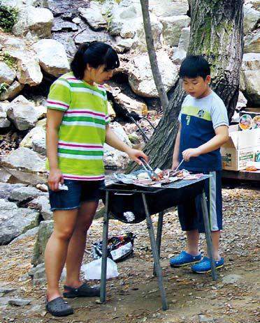 Two children barbecue at the Natural Camp Site at Seoul Grand Park. (Julie Jackson/The Korea Herald)