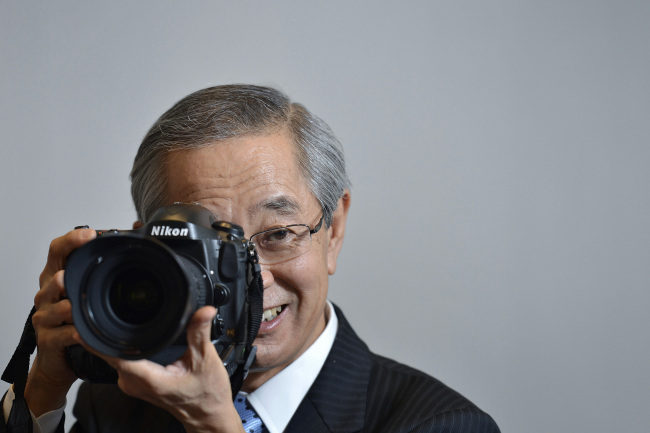 Makoto Kimura, president of Nikon Corp., holds a Nikon D4 digital single-lens reflex camera as he poses for a photograph at the company’s head office in Tokyo on July 4. (Bloomberg)