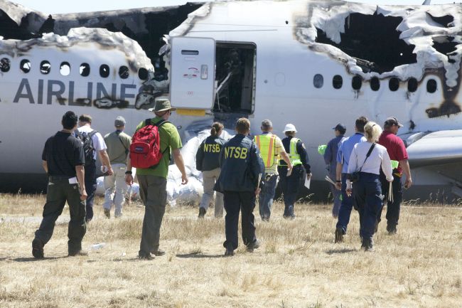 7일(현지시간) 미국 교통안전위원회(NTSB) 조사관들이 전날 샌프란시스코 공항에 착륙하던 중 충돌사고와 함께 불에 탄, 아시아나항공 OZ 214편 여객기를 조사하고 있다. 이번 사고로 탑승자 307명 가운데 2명이 사망하고 182명이 부상했다. (AP-연합뉴스)