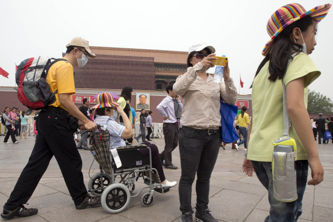 Visitors to Tiananmen Gate wear masks during a day of heavy pollution in Beijing on May 7. ( AP-Yonhap News)