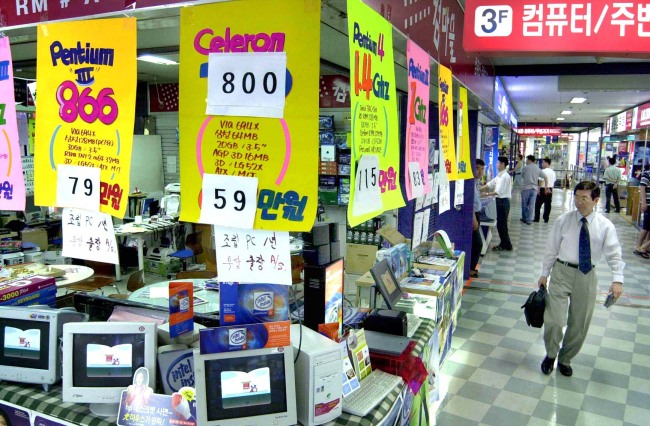 A man walks past a shop selling personal computers in Seoul. (The Korea Herald)