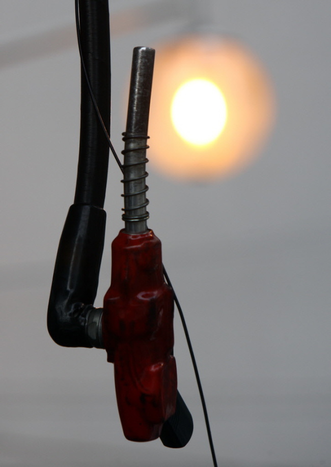 A fuel nozzle gun hangs at a gas station in Tokyo. (Bloomberg)