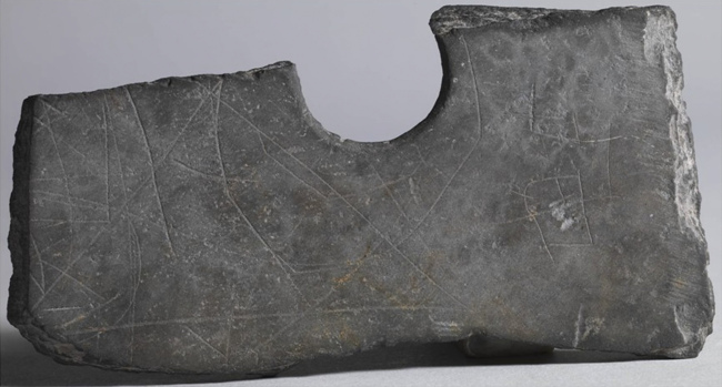 This undated photo shows a piece of a stone ax with etched markings which was unearthed near Zhuangqiao grave relic in Pinghu, Zhejiang Province, China. ( AP-Yonhap News)