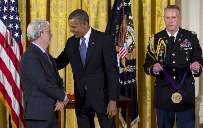 President Barack Obama talks to director George Lucas on Wednesday in the East Room of the White House in Washington, where he awarded him with the 2012 National Medal of Arts. (AP-Yonhap News)