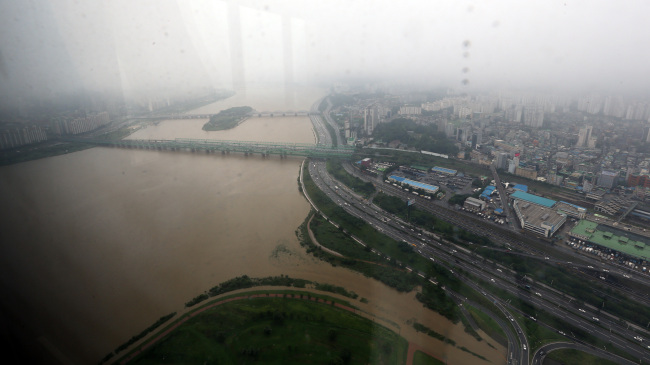 Muddy water fills the Han River after heavy rainfall hit the capital over the weekend. (Yonhap News)