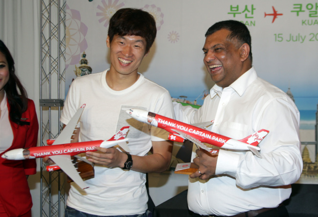 AirAsia CEO Tony Fernandes (right), the chairman of English soccer club Queens Park Rangers, poses with the club’s Korean star Park Ji-sung, holding model AirAsia aircraft, at the launch of AirAsia X’s Busan-Kuala Lumpur route in Busan on Monday. (Yonhap news)