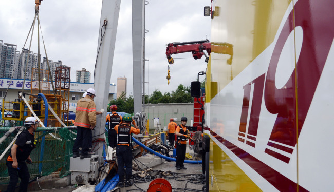 Rescuers work at a reservoir construction site in Seoul on Tuesday after an accident that killed one worker and left six others missing Monday. (Ahn Hoon/The Korea Herald)