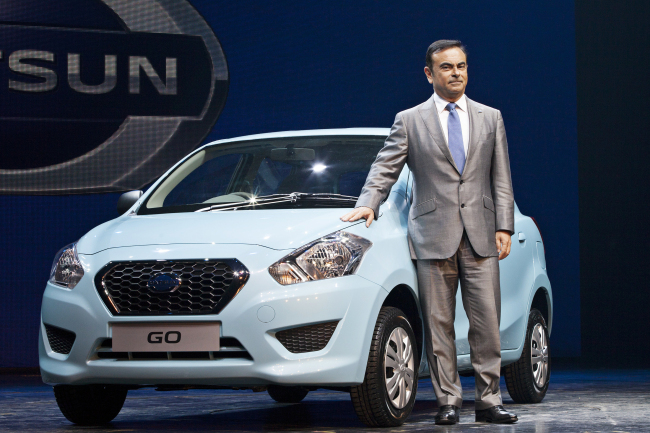 Carlos Ghosn, chief executive officer of Nissan Motor Co., stands with the company’s new Datsun Go vehicle at a media event in Gurgaon, India, Monday. (Bloomberg)