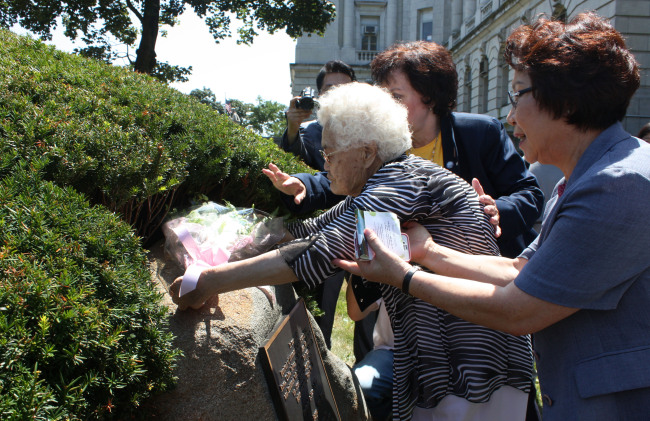 Yi Ok-seon, a former South Korean comfort woman, places flowers at a monument honoring the women forced by Japan into sexual slavery for its troops during World War II, in Bergen County, New Jersey, Monday. (Yonhap News)