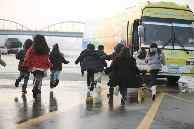 Kids run toward the newly created “Moving Arts Bus.” (Ministry of Culture, Sports and Tourism)