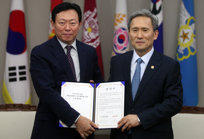 Minister of National Defense Kim Kwan-jin (right) and Lotte Group chairman Shin Dong-bin pose after signing an agreement on projects for Korean War veterans at the ministry headquarters in Seoul on Wednesday. (Yonhap News)