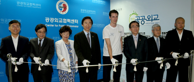 Foreign Minister Yun Byung-se (fourth from left) and other officials cut the tape in a ceremony to open the Center for Public Diplomacy in the ministry in Seoul on Wednesday. From left are Han Choong-hee, director-general for cultural affairs; Shin Dong-ik, deputy minister for multilateral and global affairs; Kim Yang-ja, a member of the senior public diplomatic corps; Yun; Jeroen Tonnon, a Dutch student at Korea University; Cho Tae-yul, vice foreign minister; Ma Young-sam, ambassador for public diplomacy; and Kim Min-soo, a singer and songwriter. (Yonhap News)