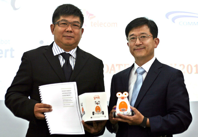 SK Telecom smart learning business chief Kim Don-jung (right) poses with CommBax chief K. C. Tan after signing an agreement on its exports of robots to the Malaysian firm in Kuala Lumpur on Monday. (SKT)