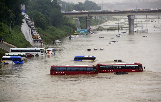 Tens of cars sit submerged in a flooded riverside parking lot in Tancheon, Songpa-gu, southern Seoul after heavy rain hit the city and surrounding areas. (Park Hae-mook/The Korea Herald)