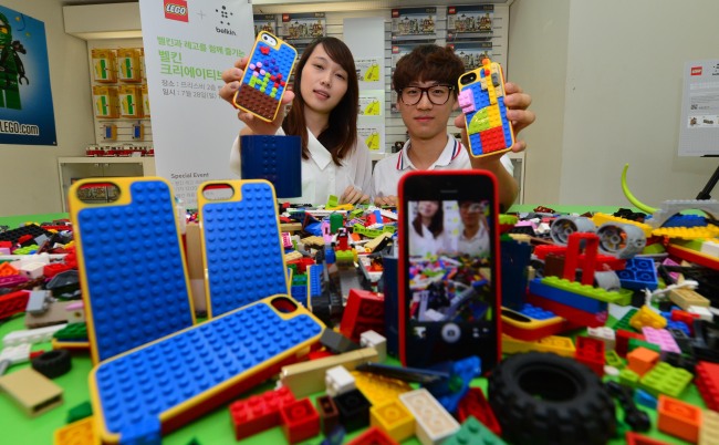 Models promote the LEGO Builder Case for iPhone 5, jointly manufactured by the toy maker and Belkin International at a launch in Seoul on Sunday. (Lee Sang-sub/The Korea Herald)