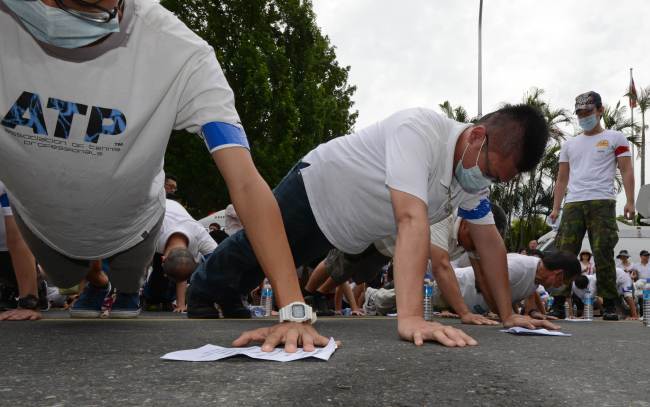 Protesters do push-ups during an anti-military rally outside the Defense Ministry in Taipei. (AFP-Yonhap News)