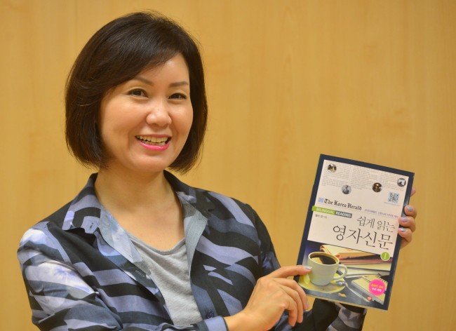 Bella Chung poses with her book “Bilingual Reading” during an interview with The Korea Herald on Tuesday. (Lee Sang-sub/The Korea Herald)