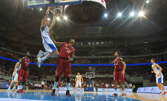 South Korea`s Kim Jong-kyu dunks the basketball over Qatari defenders during the quarterfinals of Asian men`s basketball championship against Qatar in the Philippines. South Korea won 79-52. (Yonhap News)