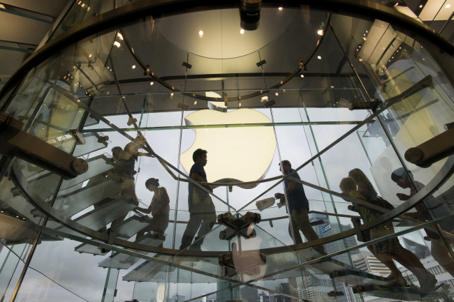 Customers walk up and down a staircase at an Apple Inc. store in Hong Kong. (Bloomberg)