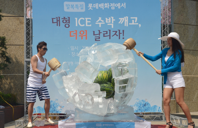 Lotte Department Store on Sunday invited customers to help break the ice surrounding watermelons. They then shared the fruit afterward to help chase the heat ahead of the last hottest day of the year that falls on Monday. (Chung Hee-cho/ The Korea Herald)